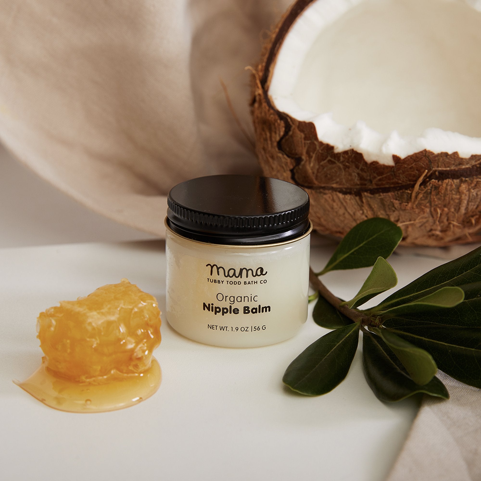 Nipple Balm jar next to honey and coconut
